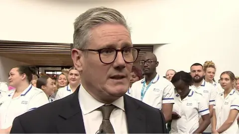 Sir Keir Starmer wearing a suit and a brown tie
