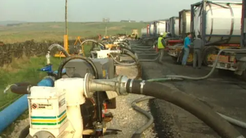 An image from 1995 of water tankers connected to pipes