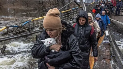 EPA People from Irpin leave town by damaged bridge - 7 March