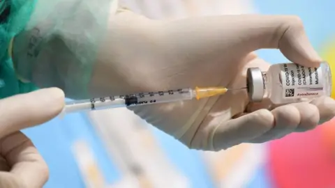 Getty Images A medical worker fills a syringe from a vial of the British-Swedish AstraZeneca/Oxford vaccine