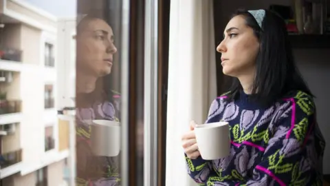 Woman looking out of window (file image)