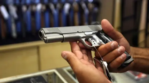 Getty Images A man chooses a gun at the Gun Gallery in Glendale, California, 18 April 2007.