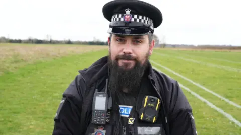 BBC Police officer wearing uniform and beard