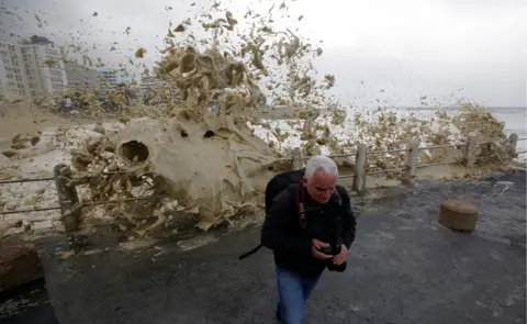 Reuters A man runs from sea spray as storms hit Cape Town, South Africa, June 7, 2017.