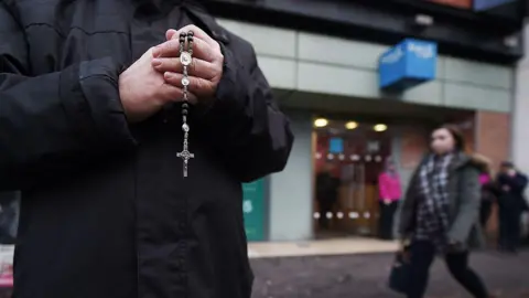 Getty Images Man holding rosary beads outside abortion clinic 