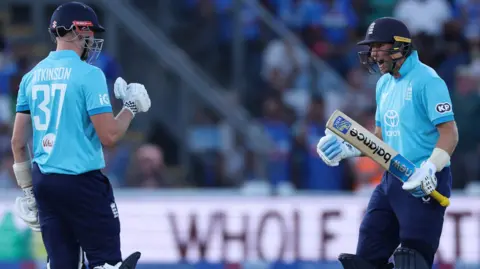 Joe Root, right, roars in the direction of Gus Atkinson as England seal victory over India
