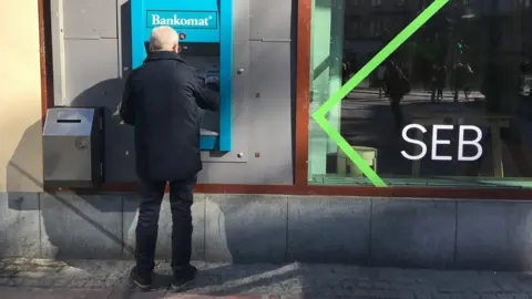 Old person using a cash machine