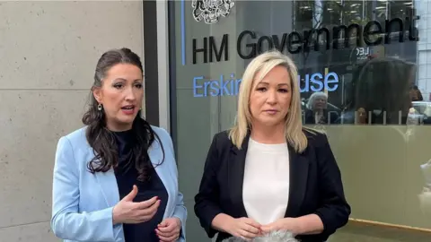 David Young/PA Deputy First Minister Emma Little-Pengelly and First Minister Michelle O'Neill standing outside the NIO