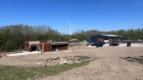 LDRS A wide shot of the Bennerley Viaduct visitor centre construction site. They are two cabins for the visitor centre and some industrial units in the background. 