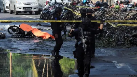 EPA Indonesian police patrol outside a church after a suicide bomb in Surabaya, Indonesia. Photo: 13 May 2018