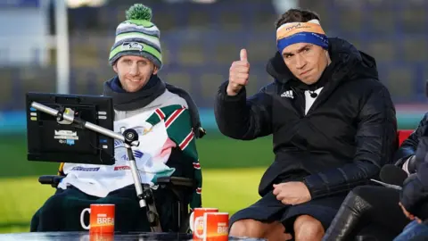 PA Media Kevin Sinfield puts his thumb up, sat alongside Rob Burrow