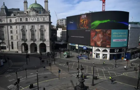 Getty Images Piccadilly Circus in central London is seen at lunch time on March 21, 2020, a day after the British government said it would help cover the wages of people hit by the coronavirus outbreak as it tightened restrictions to curb the spread of the disease.