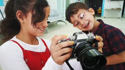 Kate Green Refugee children with camera