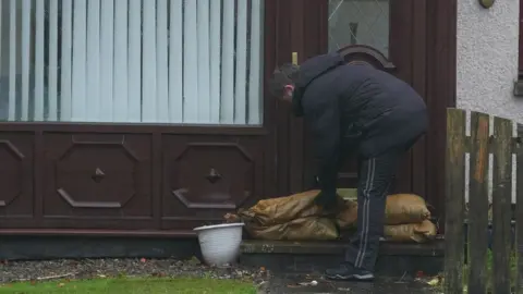 PA Media man with sandbags in Brechin