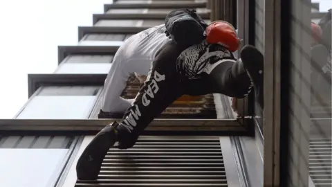 PA Alain Robert climbing the Heron Tower