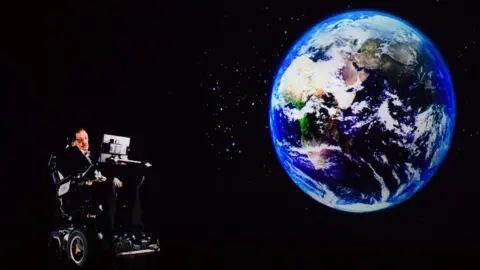 AFP In this file photo taken on March 24, 2017, renowned physicist Stephen Hawking, 75, speaks to an audience by hologram (L) in Hong Kong, beamed live from his office in Cambridge, England.