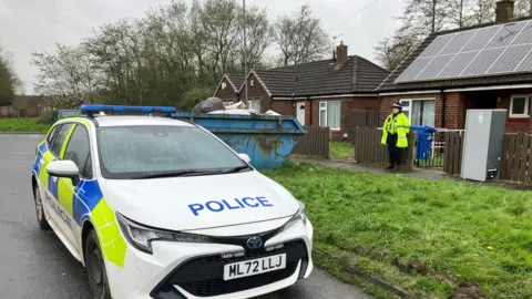 BBC A police car at the scene