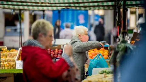 Aled Llywelyn/BBC Shoppers at a fruit and veg stall