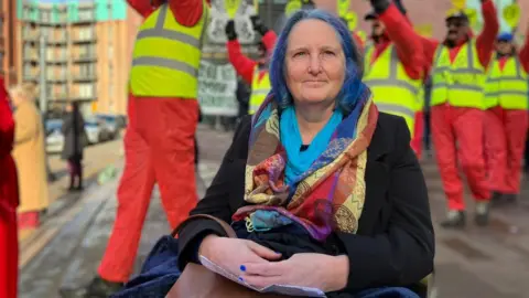 A women outside court campaigning against Bristol Airport's expansion