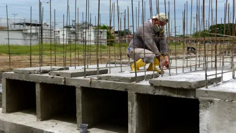 EPA A man works making tombs for victims of Covid-19 at Angel Maria Canales cemetery in Guayaquil, Ecuador, 15 April 2020