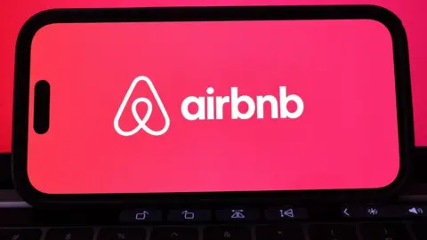 Getty Images Airbnb logo on phone.