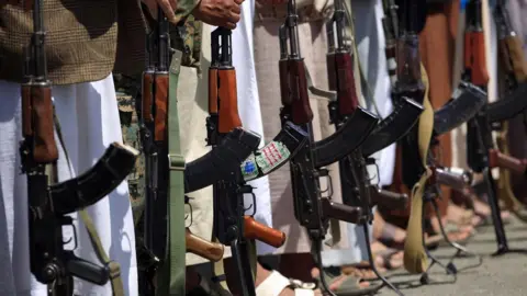 AFP Tribal gunmen loyal to Yemen's rebel Houthi movement hold their weapons during a rally in Sanaa (27 September 2018)