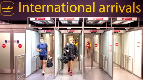 PA Media Masked passengers arriving at Gatwick airport