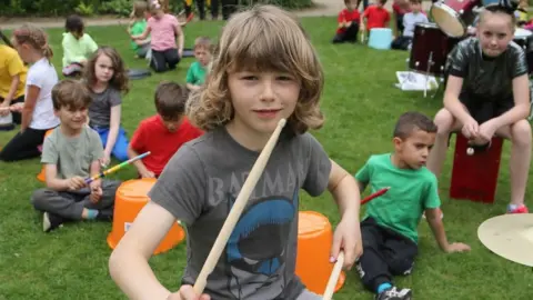 National Trust/Jason Lock Merrick Surman and local children drumming at the National Trust's Quarry Bank Mill