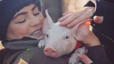 Happy Pants Ranch Amey James, pictured with one of the piglets, said the stress is making her ill