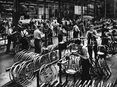 Getty Images Workers assembling bicycles inside a Raleigh factory in the early 1900s