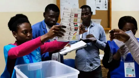 A polling station official shows a ballot during the counting of votes at the end of the general election in Luanda