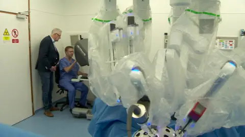 The robotic limbs are controlled remotely by the consultant surgeon