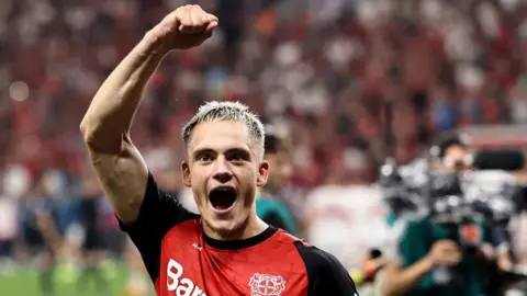 Florian Wirtz celebrates with his arm aloft