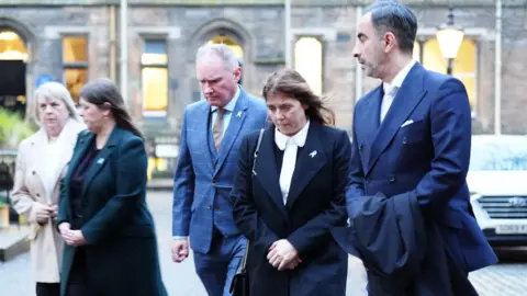 PA Media Solicitor Aamer Anwar (right), Tracy Scott (second right) and Ethan's step-father Colin Scott (third right) outside Bute Hall in Glasgow ahead of the graduation ceremony in December.