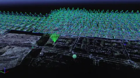 Ordnance Survey An aerial view of housing depicted on a computer screen, with a graphic of a large cluster green triangles suspended in the sky above, with green lines descending to a central point