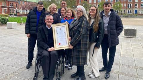 Disability and equality campaigner, David Thompson is presented with a framed certificate as he is made a honorary freeman of the borough of Warrington