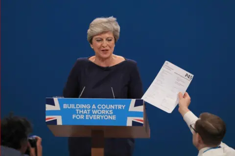 Peter Byrne/PA Comedian Simon Brodkin, also known as Lee Nelson confronts Prime Minister Theresa May during her speech at the Conservative Party Conference at the Manchester Central Convention Complex in Manchester.