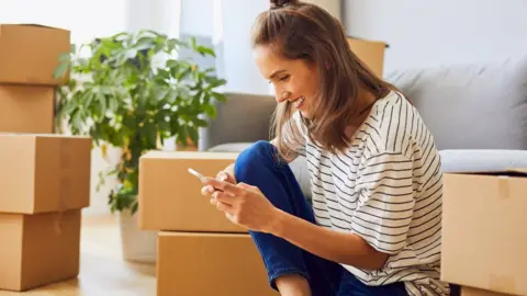 Getty Images Young woman moving house