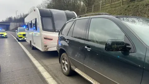 North Yorkshire Police Car towing a caravan being followed by police cars