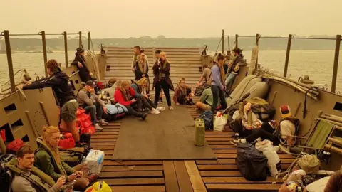 FRAN LAWSON Evacuees onboard a naval vessel taking them away from Mallacoota