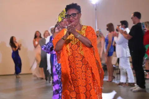 Getty Images Women walk down a runway.