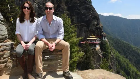 PA Media Duke and Duchess of Cambridge sit on steps wearing under glasses