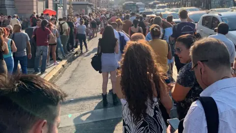 People wait in a long queue outside the Constitucion subway station due to a power blackout in Buenos Aires, Argentina, March 1, 2023,