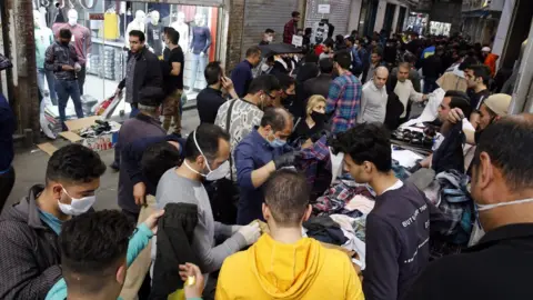 EPA Iranians shop at Tehran's Grand Bazaar on 18 March 2020