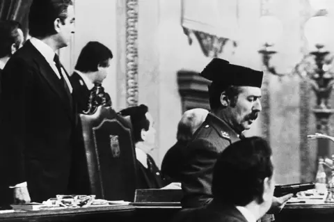 AFP Lt-Col Antonio Tejero de Molina (C) brandishes his pistol in the Spanish parliament, 23 February 1981