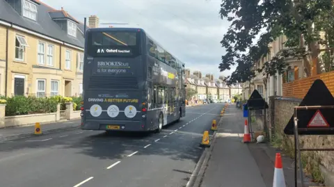 A bus driving along Abbey Road in Oxford.