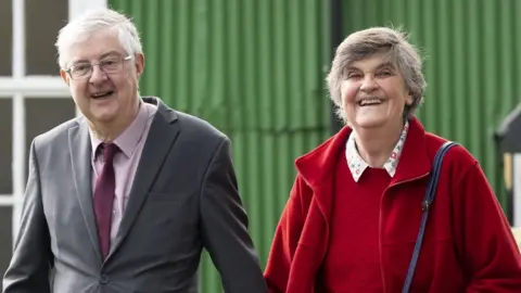 Getty Images First Minister of Wales Mark Drakeford leaves the Kings Road polling station in Pontcanna with his wife Clare after voting on May 5, 2022 in Cardiff, Wales.