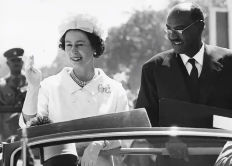 Getty Images HM Queen Elizabeth II and President El Tigani El-Mahi, in a car together on the state drive from Khartoum Airport on a royal visit, Sudan, February 11th 1965.