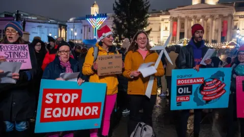 Getty Images Protestors in Trafalgar square with placards criticising Equinor