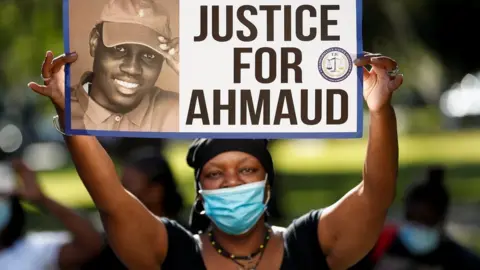Reuters Protester holds banner calling for justice for Ahmaud Arbery